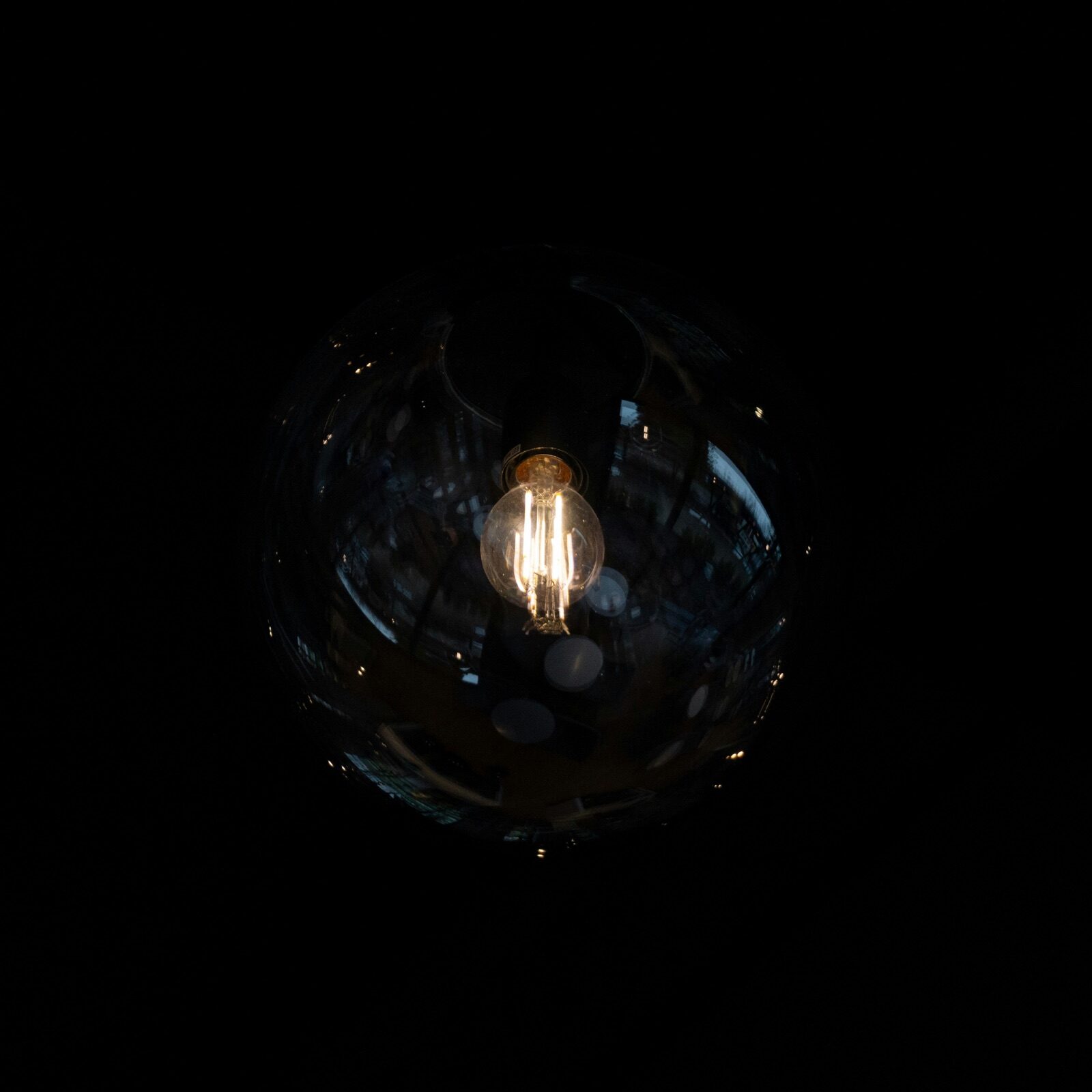 Light bulb glowing inside a glass sphere for Epo-Weld™ UHTC ultra high temperature coating uncoated glass headlamp