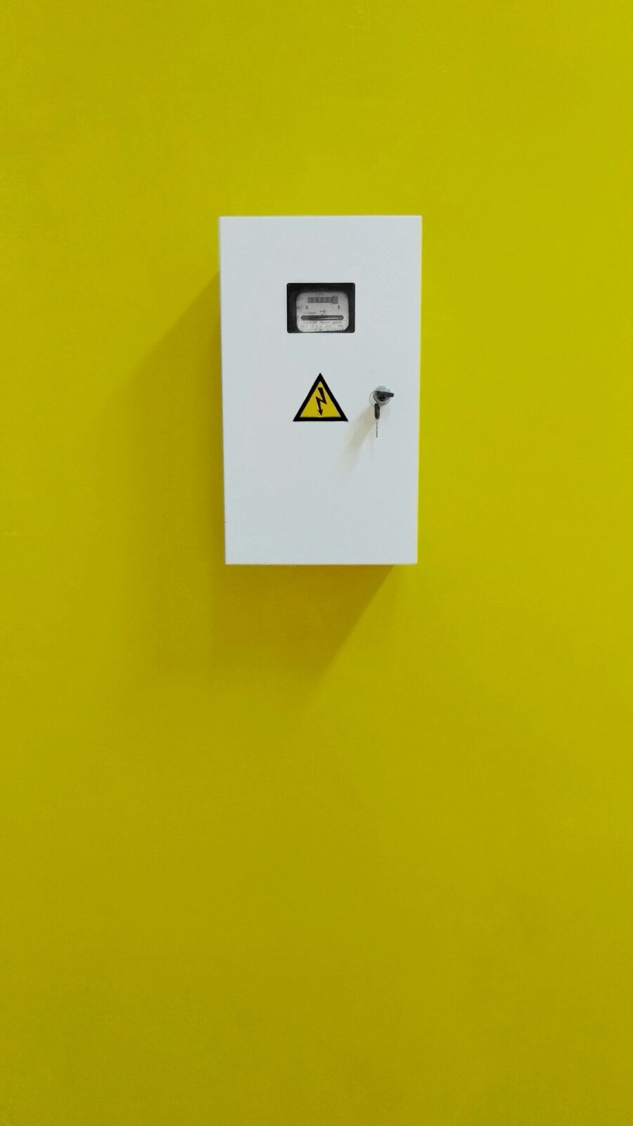 White electrical enclosure on a yellow wall for Pyra-Sil™ RTV silicone electrical enclosure weatherproof IP sealing